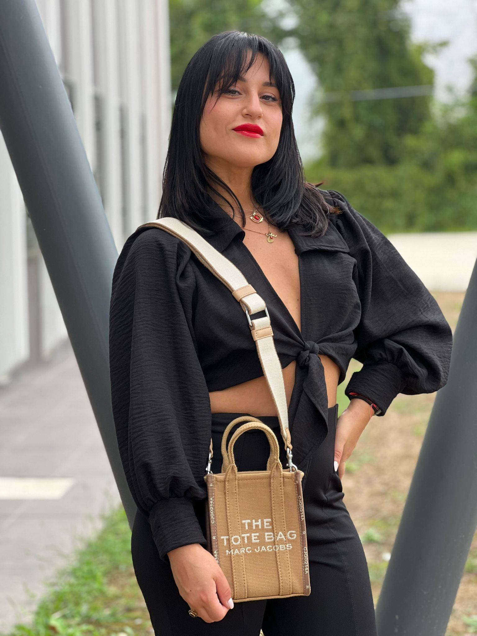 Ragazza chi indossa The Tote Bag Marc Jacobs in tessuto Jacquard con tracolla regolabile e amovibile in tessuto Bianco, rifinita con parti metalliche argentate.