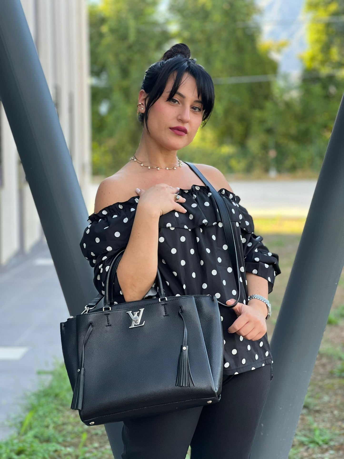 indossata Borsa LV in pelle nera con parti metalliche argentate; munita di doppi manici stondati e una tracolla amovibile. 