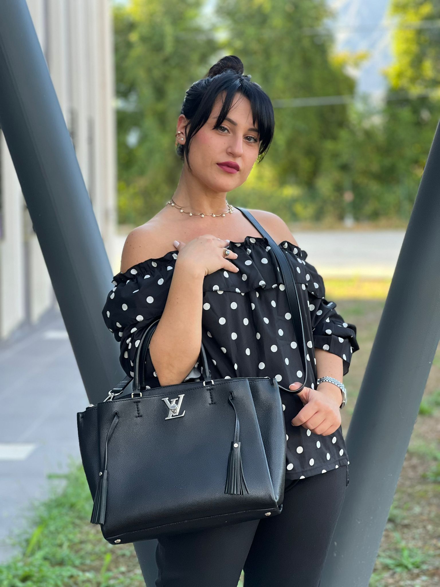 indossata Borsa LV in pelle nera con parti metalliche argentate; munita di doppi manici stondati e una tracolla amovibile. 