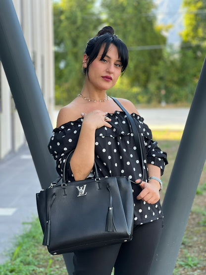 indossata Borsa LV in pelle nera con parti metalliche argentate; munita di doppi manici stondati e una tracolla amovibile. 