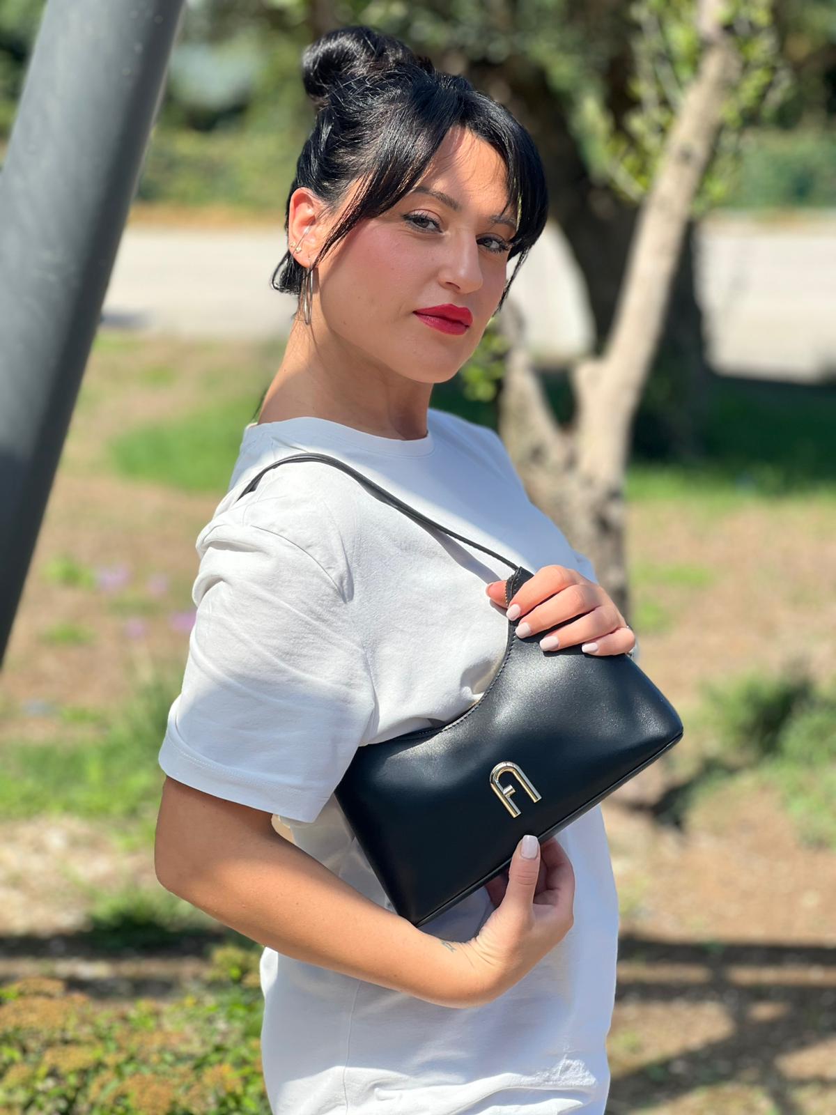 indossata Borsa Furla in pelle nera con parti metalliche dorate; munita di un manico singolo, indossabile a spalla. Completa di dustbag e cartellino 