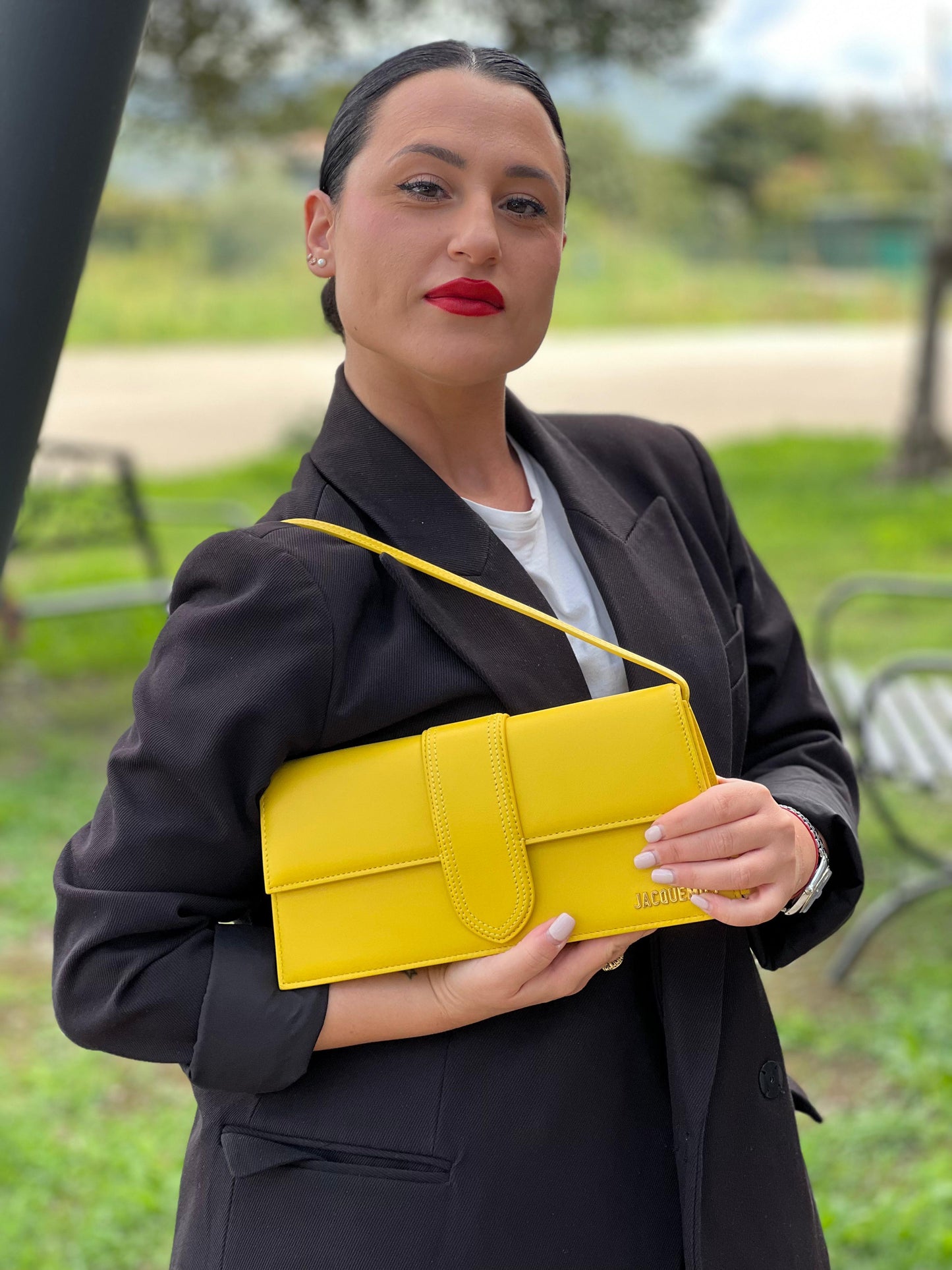 indossata Borsa Jacquemus Le Bambino Long in pelle gialla con parti metalliche dorate; munita di un manico singolo. Completa di dustbag e cartellini, di lusso, originale, ottime condizioni.