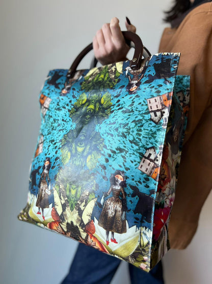 Ragazza chi indossa Borsa Furla in fibra sintetica multicolore stampata con fantasia artistica surreale e manici rigidi marroni in acetato con inserti metalliche dorate. Completa di dustbag. Originale, usata, di lusso, in ottime condizioni