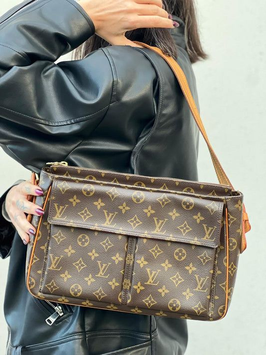 Ragazza che indossa una Borsa LV Viva Cité in canvas monogram con finiture in vacchetta naturale e parti metalliche dorate; indossabile a spalla. Completa di dustbag. Originale, usata, di lusso, in ottime condizioni.