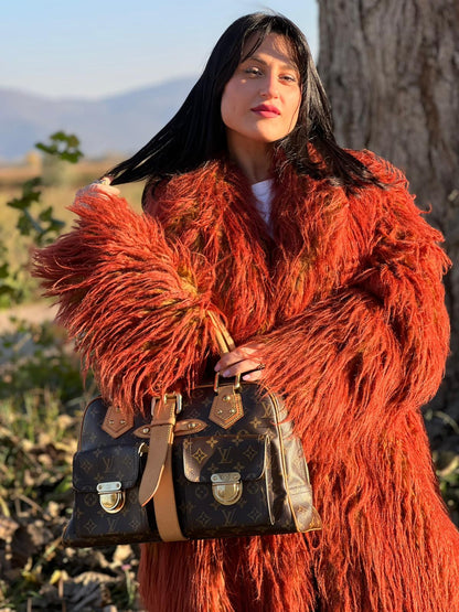 Ragazza che indossa una Borsa Louis Vuitton in canvas marrone monogram con finiture in vacchetta naturale e parti metalliche dorate; munita di doppi manici. Indossabile a mano. Originale, usata, di lusso in ottime condizioni