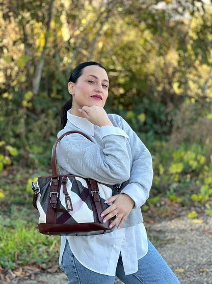Ragazza che indossa una Borsa Tote Burberry in tessuto bianco trama tartan nera e rossa, finiture in pelle marrone e parti metalliche effetto renio, munita di doppie manici e una tracolla regolabile, amovibile con spallaccio. Indossabile a spalla. Originale, usata, di lusso, in ottime condizioni.