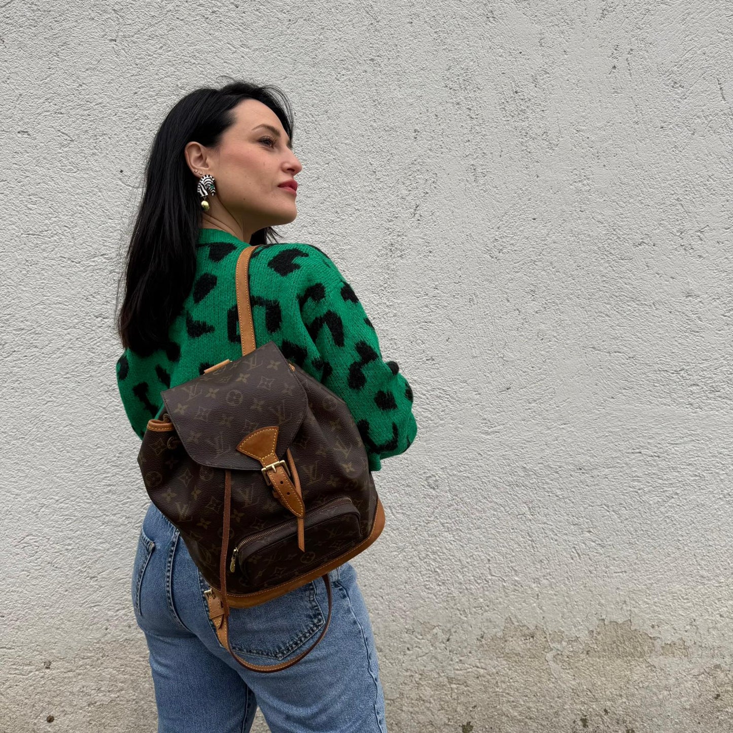 Ragazza che indossa un Zaino Montsouris PM in canvas marrone monogram con finiture in vacchetta naturale e parti metalliche dorate, munito di un Anello da portare a mano e una tracolle in vacchetta regolabile con fibbie. Originale, usato , di lusso, in ottime condizioni.