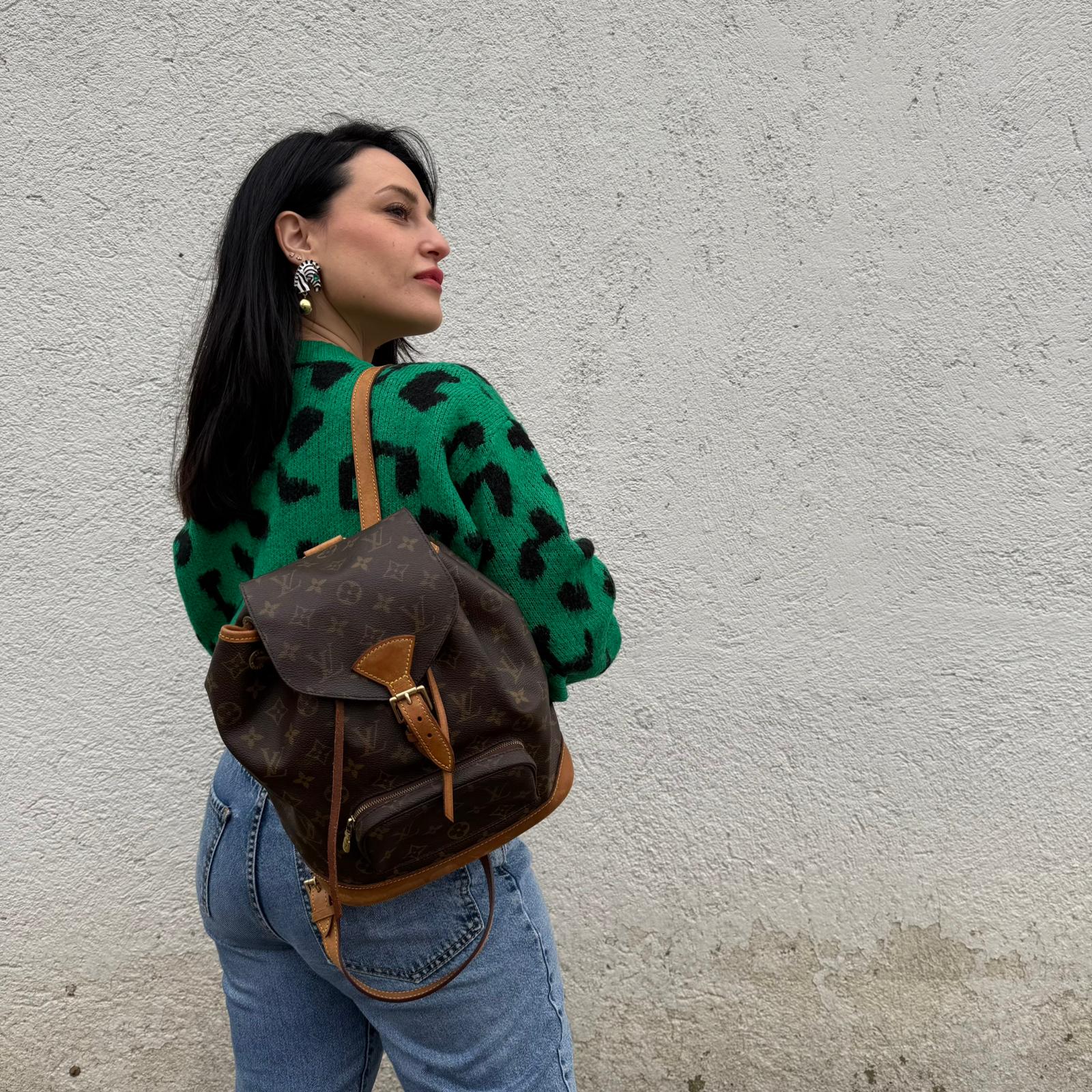 Ragazza che indossa un Zaino Montsouris PM in canvas marrone monogram con finiture in vacchetta naturale e parti metalliche dorate, munito di un Anello da portare a mano e una tracolle in vacchetta regolabile con fibbie. Originale, usato , di lusso, in ottime condizioni.