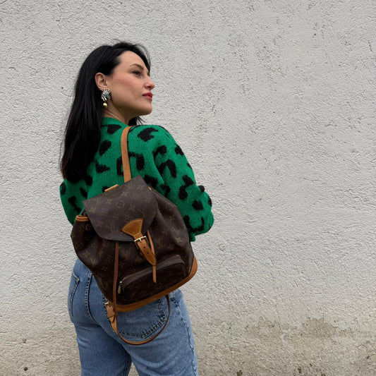 Ragazza che indossa un Zaino Montsouris PM in canvas marrone monogram con finiture in vacchetta naturale e parti metalliche dorate, munito di un Anello da portare a mano e una tracolle in vacchetta regolabile con fibbie. Originale, usato , di lusso, in ottime condizioni.