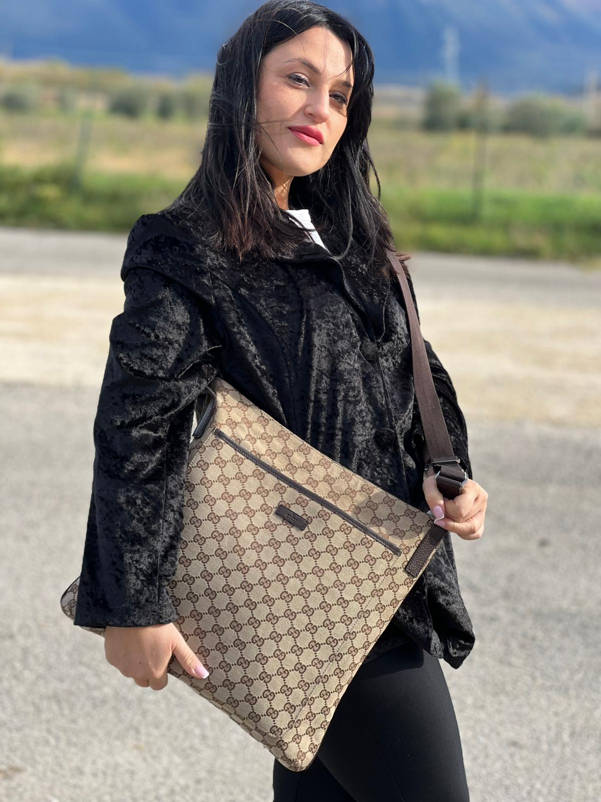 Ragazza che indossa una Borsa Gucci in tessuto GG beige con finiture in pelle marroni, munita di una tracolla in tessuto regolabile. Indossabile a spalla. Originale, usata, di lusso, in ottime condizioni.