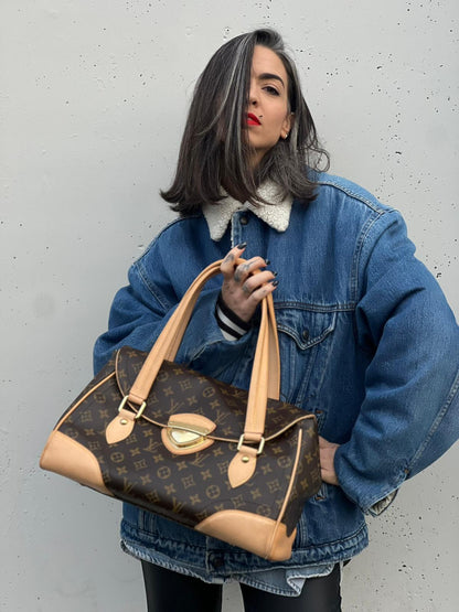 Ragazza che indossa una Borsa Beverly LV in canvas marrone monogram, finiture in vacchetta naturale e metalleria dorata. Indossabile a spalla oppure a mano. Originale, usata, di lusso, in ottime condizioni.