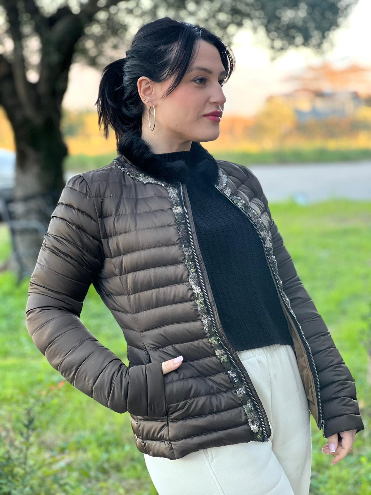 Ragazza che indossa un Piumino Colmar in100% poliestere trapuntata in tonalità bronzo, impreziosita da colletto in pelliccia sintetica e bordature con paillettes lungo la zip frontale. Originale, usato, di lusso, in ottime condizioni.