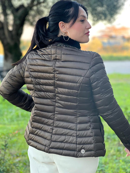 Ragazza che indossa un Piumino Colmar in100% poliestere trapuntata in tonalità bronzo, impreziosita da colletto in pelliccia sintetica e bordature con paillettes lungo la zip frontale. Originale, usato, di lusso, in ottime condizioni.