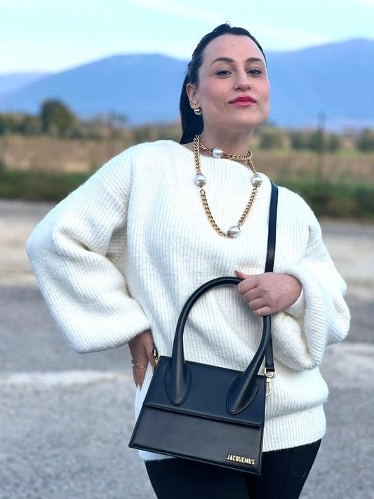 Ragazza che indossa Le Grand Chiquito Jacquemus in pelle nera con parti metalliche dorate, munita di un manico stondato e una tracolla amovibile e regolabile. Completa di dustbag e cartellino. Originale, usata, di lusso, in  ottime condizioni.