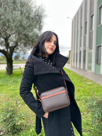 Ragazza che indossa una Borsa Yve Saint Laurent in canvas marrone monogram con parti metalliche dorate e finiture in pelle color cognac; munita di una tracolla leggermente regolabile. Completa di dustbag. Originale, usata, di lusso, in condizioni eccellenti.