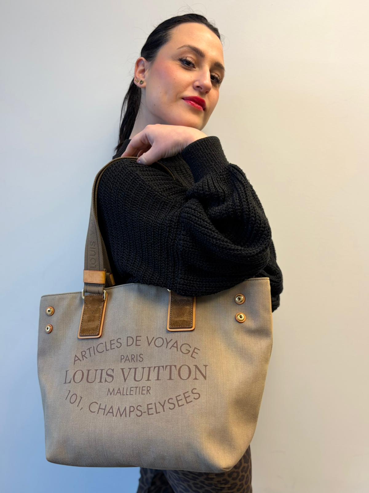 Ragazza che indossa una Borsa Louis Vuitton Limited Edition in tela beige con dettagli in pelle scamosciata marrone e in vacchetta naturale, parti metalliche dorate; munita di doppi manici in tessuto, indossabile a spalla. Completa di dustbag. Originale, usata, di lusso, in ottime condizioni