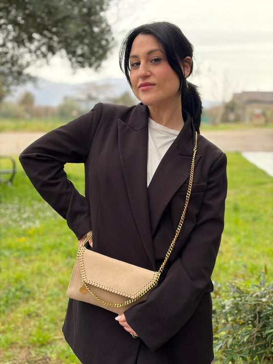 Ragazza che indossa una Borsa Falabella in tessuto vegano color Beige con parti metalliche argentate; indossabile a tracolla. Originale, usata, di lusso, in ottime condizioni.