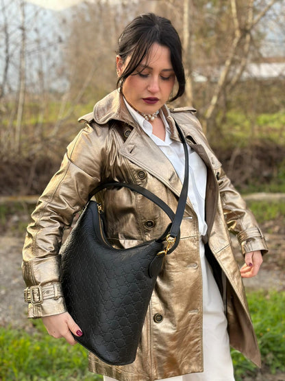 Ragazza che indossa Borsa Gucci in pelle nera GG con hardware dorato. Originale, usata, di lusso, in condizioni eccellenti.