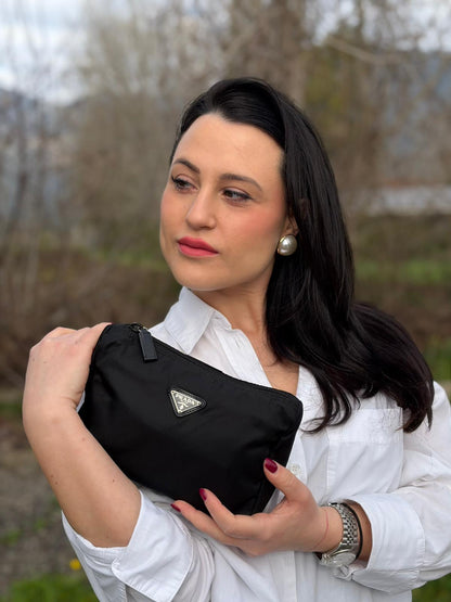 Ragazza che indossa una pouch Prada in nylon nero e hardware argentato, usata, originale, second hand, in condizioni eccellenti.