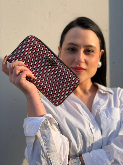 Ragazza che mostra un portafoglio Prada in pelle saffiano multicolore, decorato con stampa geometrica, usato, originale, second hand, in ottime condizioni.