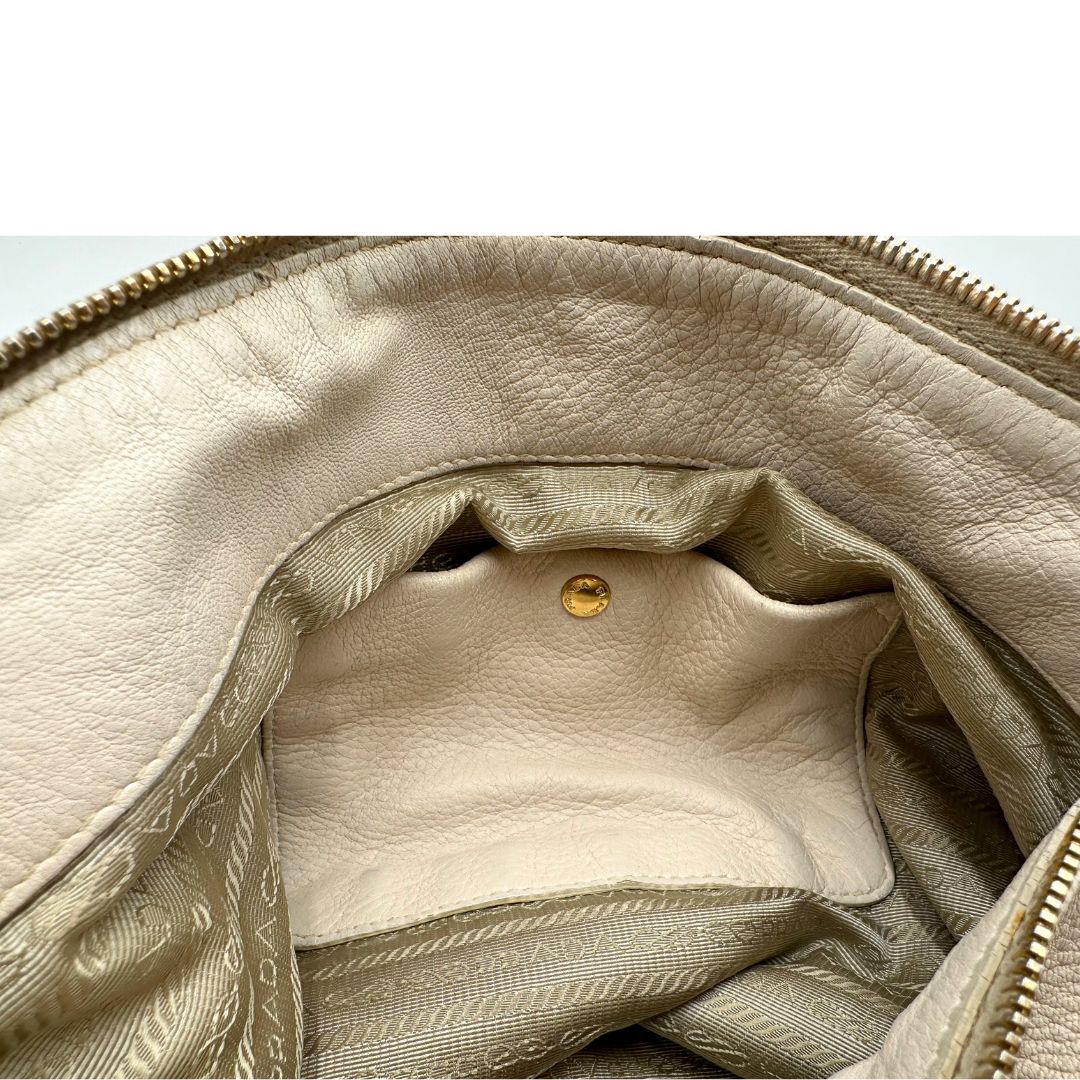 Tsaca  Borsa Prada in pelle Martellata bianca con manico singolo e metalleria dorata, da indossare a spalla. Originale, usata, di lusso, in ottime condizioni.