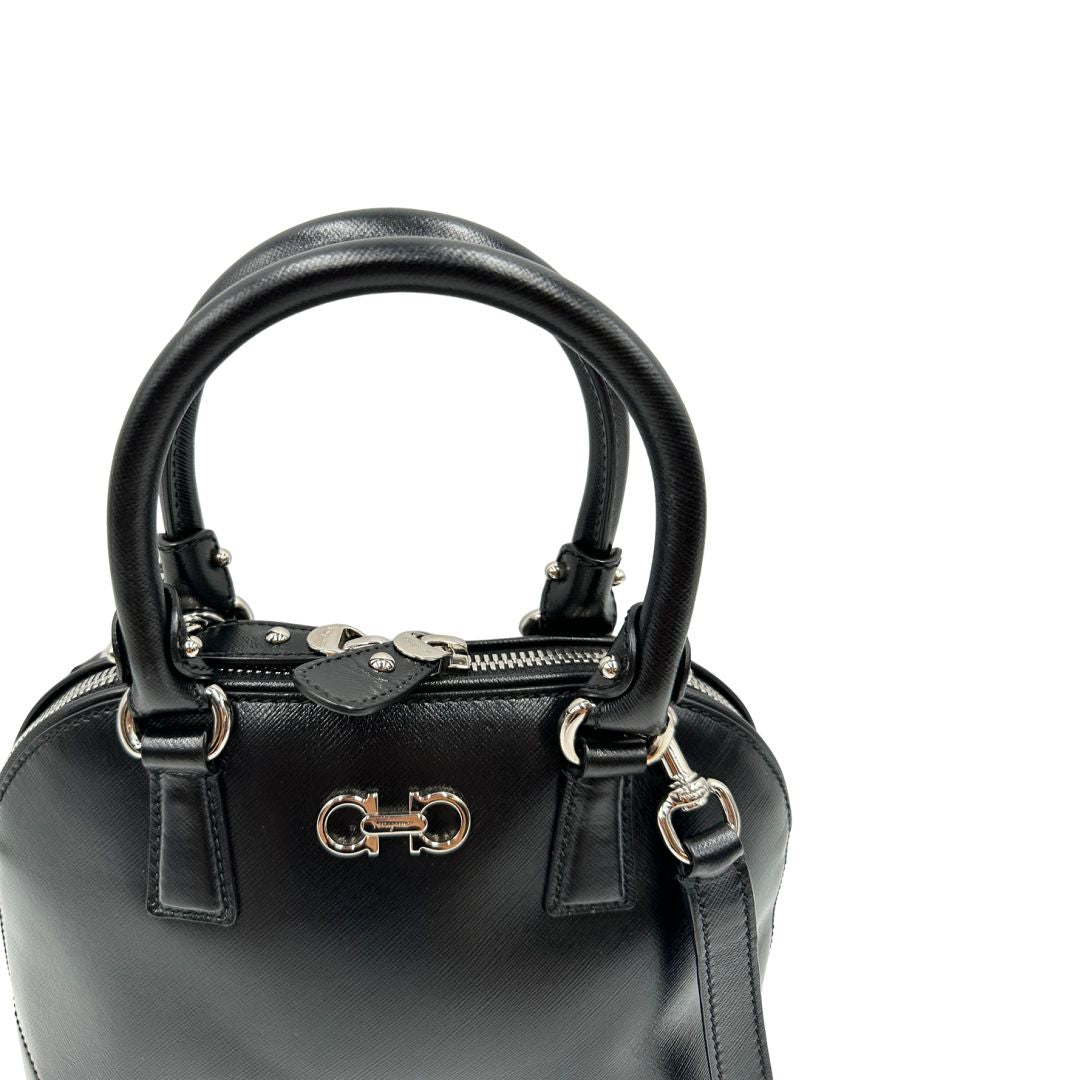 Manici Borsa Salvatore Ferragamo in pelle nera con trama Gancini e logo in metallo argentato sul front, doppi manici stondati e tracolla regolabile, e amovibile . Originale, usata, di lusso in ottime condizioni