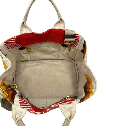 Interno di una borsa Prada in tessuto trama multicolore, con inserti metallici dorati; dotata di doppi manici e una tracolla amovibile e regolabile. Indossabile a mano o a tracolla. Completa di card d'autenticità.