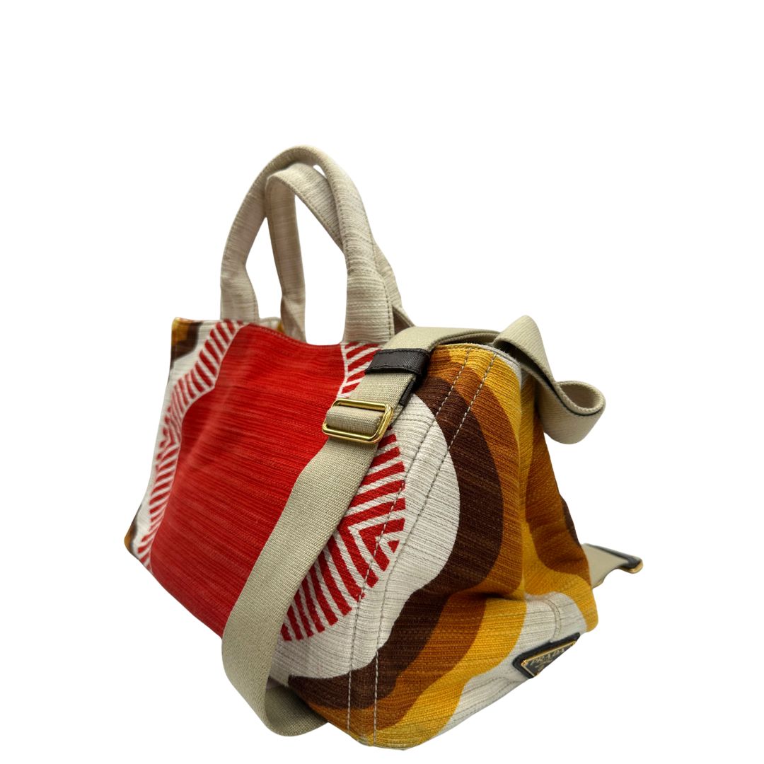 Laterale destro di una borsa Prada in tessuto trama multicolore, con inserti metallici dorati; dotata di doppi manici e una tracolla amovibile e regolabile. Indossabile a mano o a tracolla. Completa di card d'autenticità.