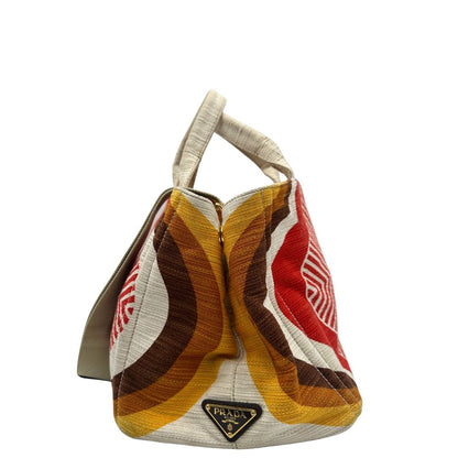 Laterale di una borsa Prada in tessuto trama multicolore, con inserti metallici dorati; dotata di doppi manici e una tracolla amovibile e regolabile. Indossabile a mano o a tracolla. Completa di card d'autenticità.
