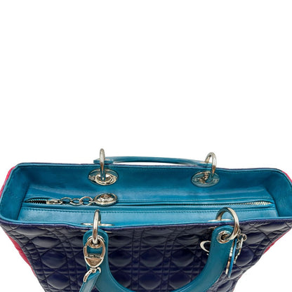 Vista superiore di una borsa Lady Dior tricolore in pelle blu, azzurra e fucsia trama cannage. Doppi manici rigidi e una tracolla amovibile, rifinita con parti metalliche argentate. Completa di dustbag.