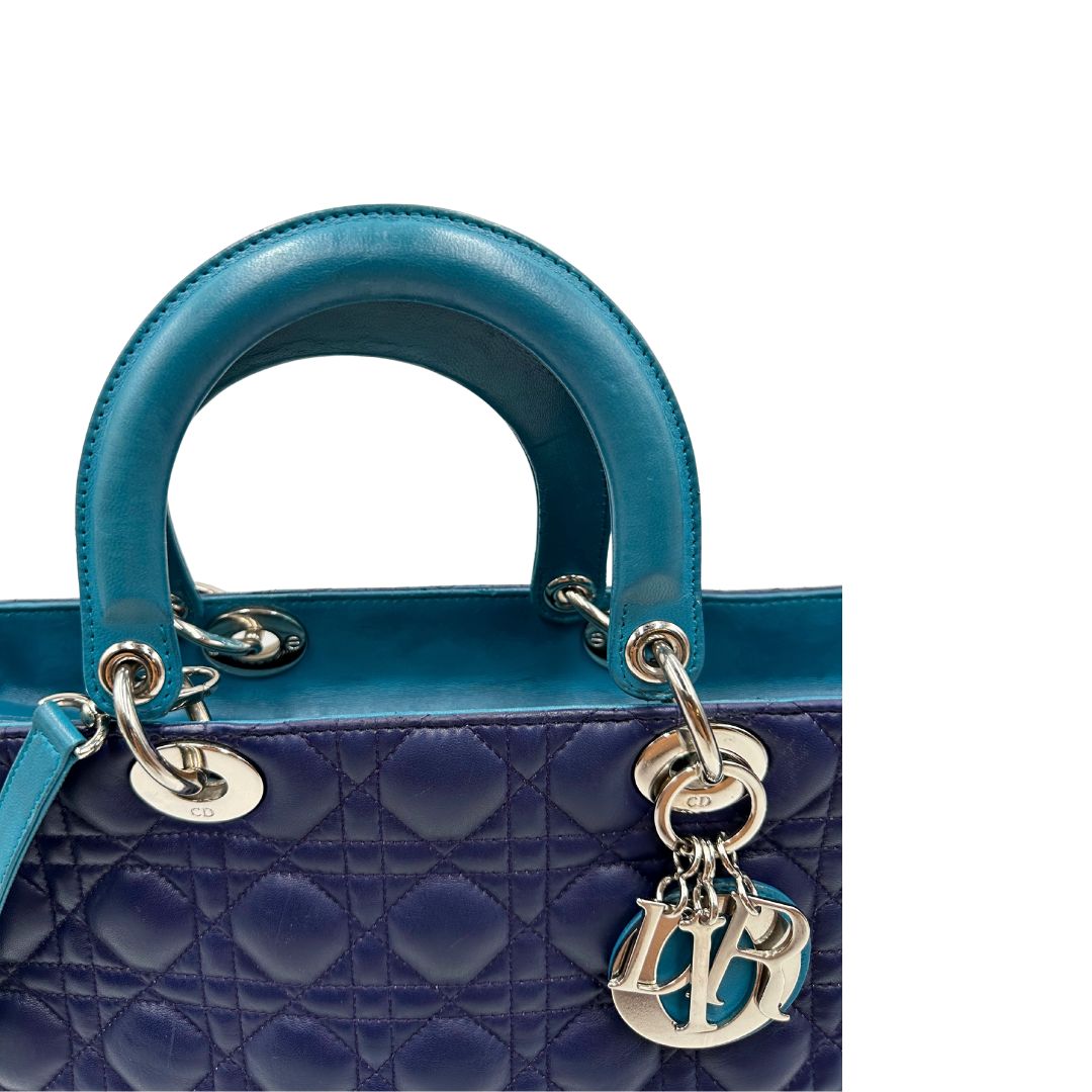 Manici e charm di una borsa Lady Dior tricolore in pelle blu, azzurra e fucsia trama cannage. Doppi manici rigidi e una tracolla amovibile, rifinita con parti metalliche argentate. Completa di dustbag.