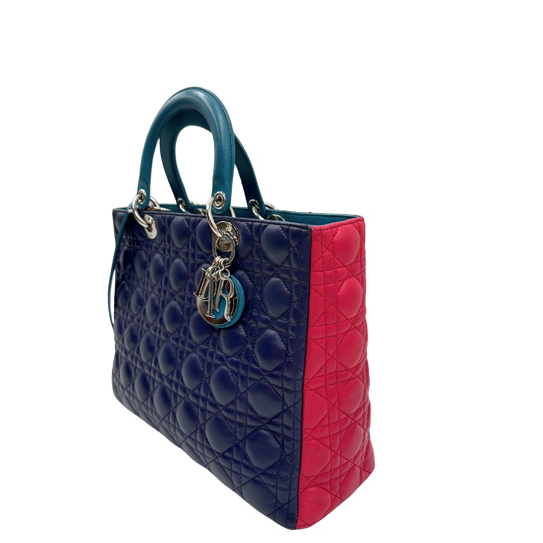 Laterale destro di una borsa Lady Dior tricolore in pelle blu, azzurra e fucsia trama cannage. Doppi manici rigidi e una tracolla amovibile, rifinita con parti metalliche argentate. Completa di dustbag.