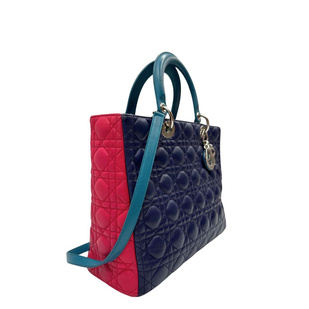 Laterale sinistro di una borsa Lady Dior tricolore in pelle blu, azzurra e fucsia trama cannage. Doppi manici rigidi e una tracolla amovibile, rifinita con parti metalliche argentate. Completa di dustbag.