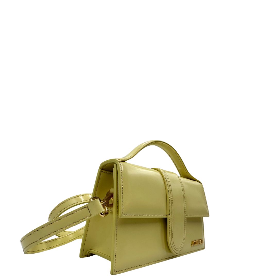 Laterali Borsa Jacquemus in pelle glacé color giallo burro con parti metalliche dorate, munita di una tracolla regolabile e amovibile e un manico singolo