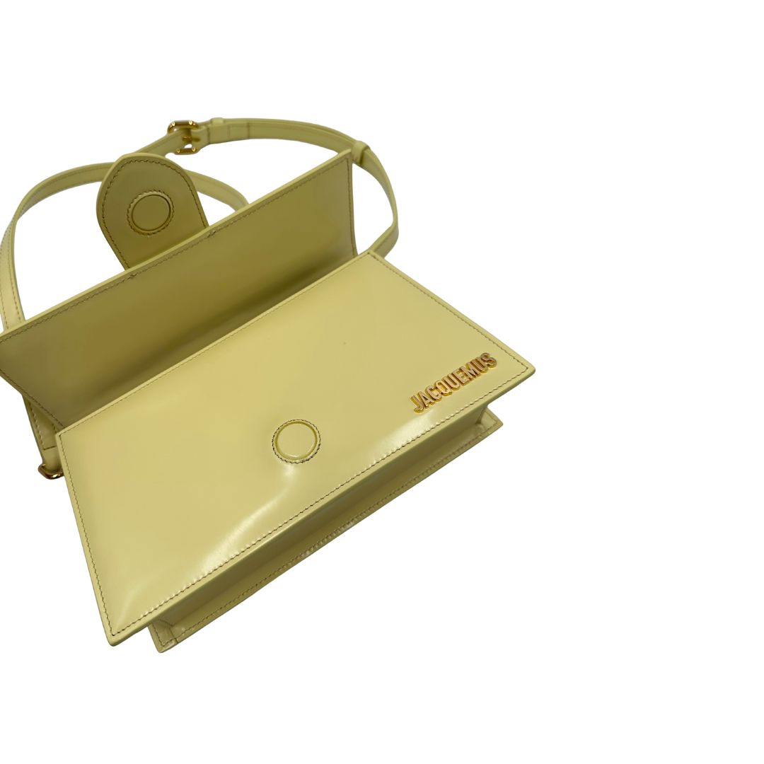 Borsa Jacquemus in pelle glacé color giallo burro con parti metalliche dorate, munita di una tracolla regolabile e amovibile e un manico singolo