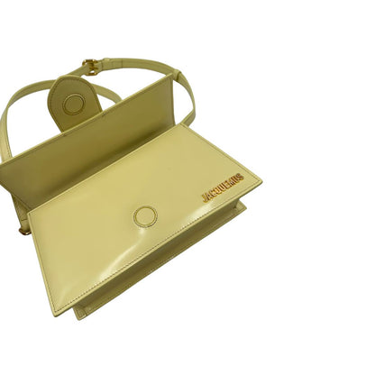 Borsa Jacquemus in pelle glacé color giallo burro con parti metalliche dorate, munita di una tracolla regolabile e amovibile e un manico singolo