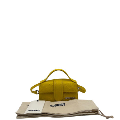 Borsa Jacquemus in pelle gialla goffrata effetto struzzo, con parti metalliche argentate munita di un manico singolo e una tracolla regolabile e amovibile. 