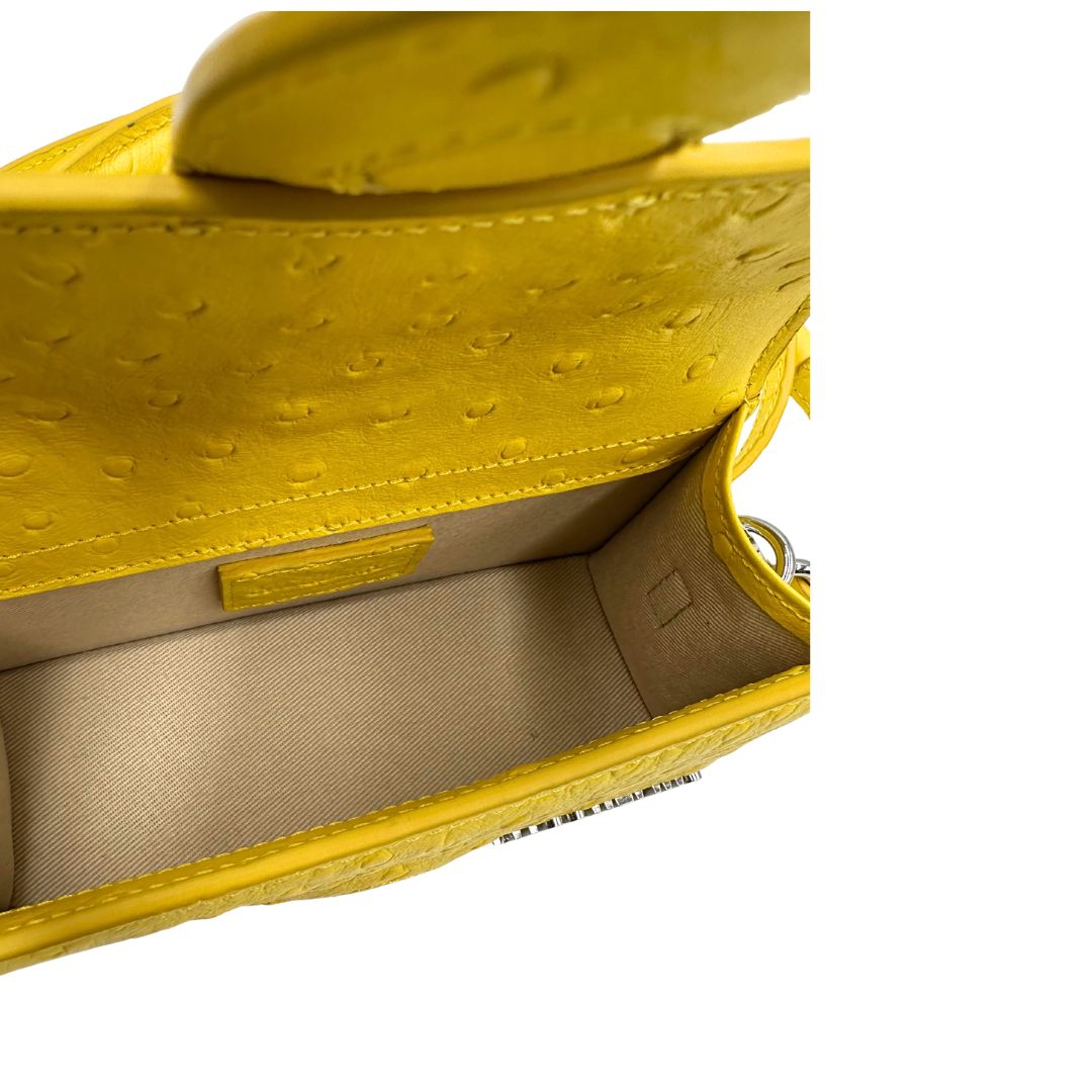 Borsa Jacquemus in pelle gialla goffrata effetto struzzo, con parti metalliche argentate munita di un manico singolo e una tracolla regolabile e amovibile. 