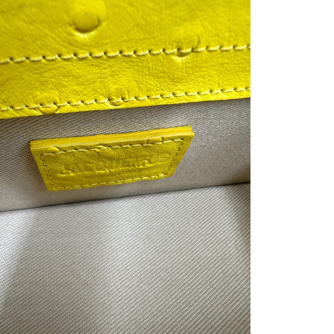 Borsa Jacquemus in pelle gialla goffrata effetto struzzo, con parti metalliche argentate munita di un manico singolo e una tracolla regolabile e amovibile. 