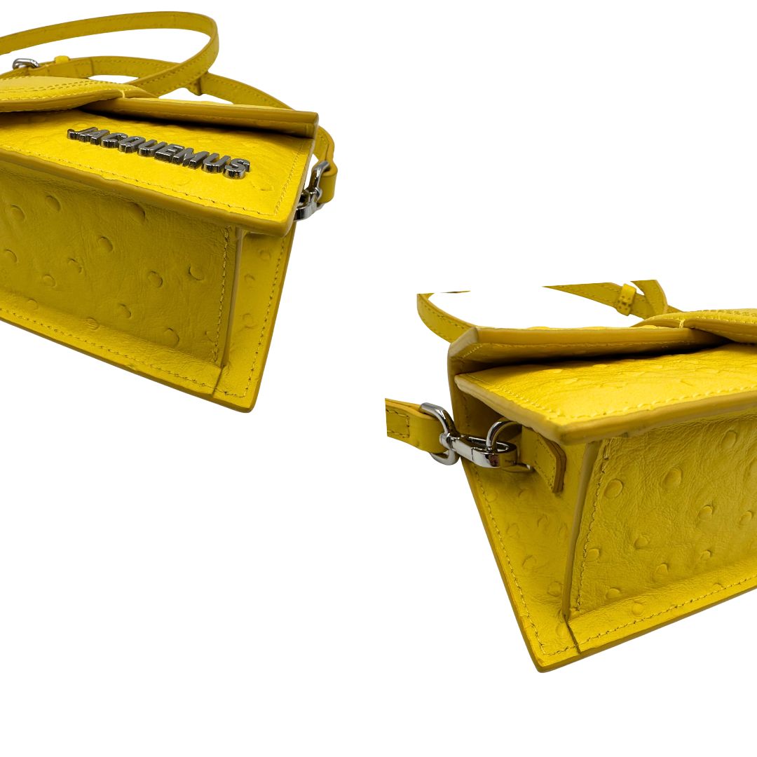 Borsa Jacquemus in pelle gialla goffrata effetto struzzo, con parti metalliche argentate munita di un manico singolo e una tracolla regolabile e amovibile. 
