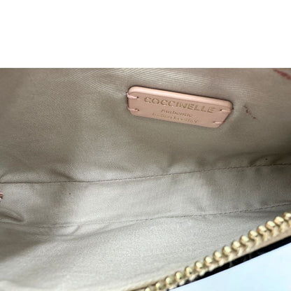 Interno Borsa Coccinelle in pelle color champagne munita di un manico singolo, una tracolla regolabile e amovibile con parti metalliche dorate. 