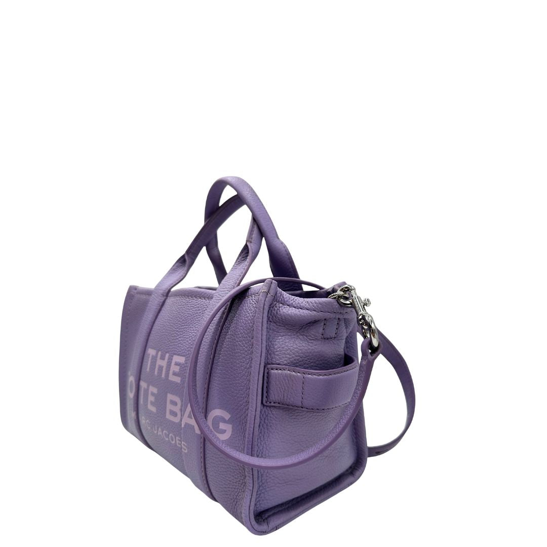 lato The Tote Bag Marc Jacobs in pelle lilla con parti metalliche argentate; munita di doppi manici e una tracolla amovibile e regolabile. Completa di dustbag, di lusso, originale, ottime condizioni.