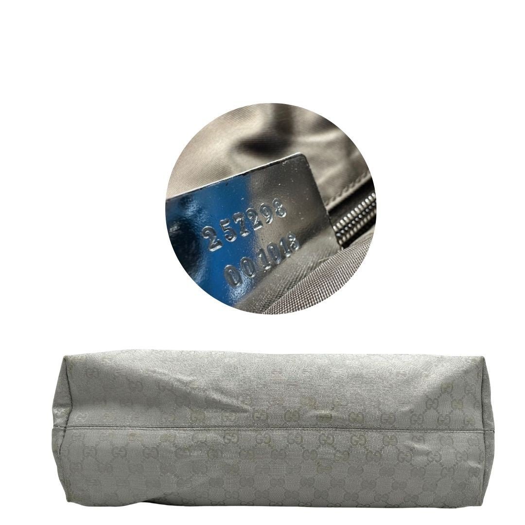 Base Borsa Gucci in canvas grigio laminato GG con finiture in pelle Tono su tono e parti metalliche argentate. Dotata di Doppi manici e tracolla in tessuto regolabile.