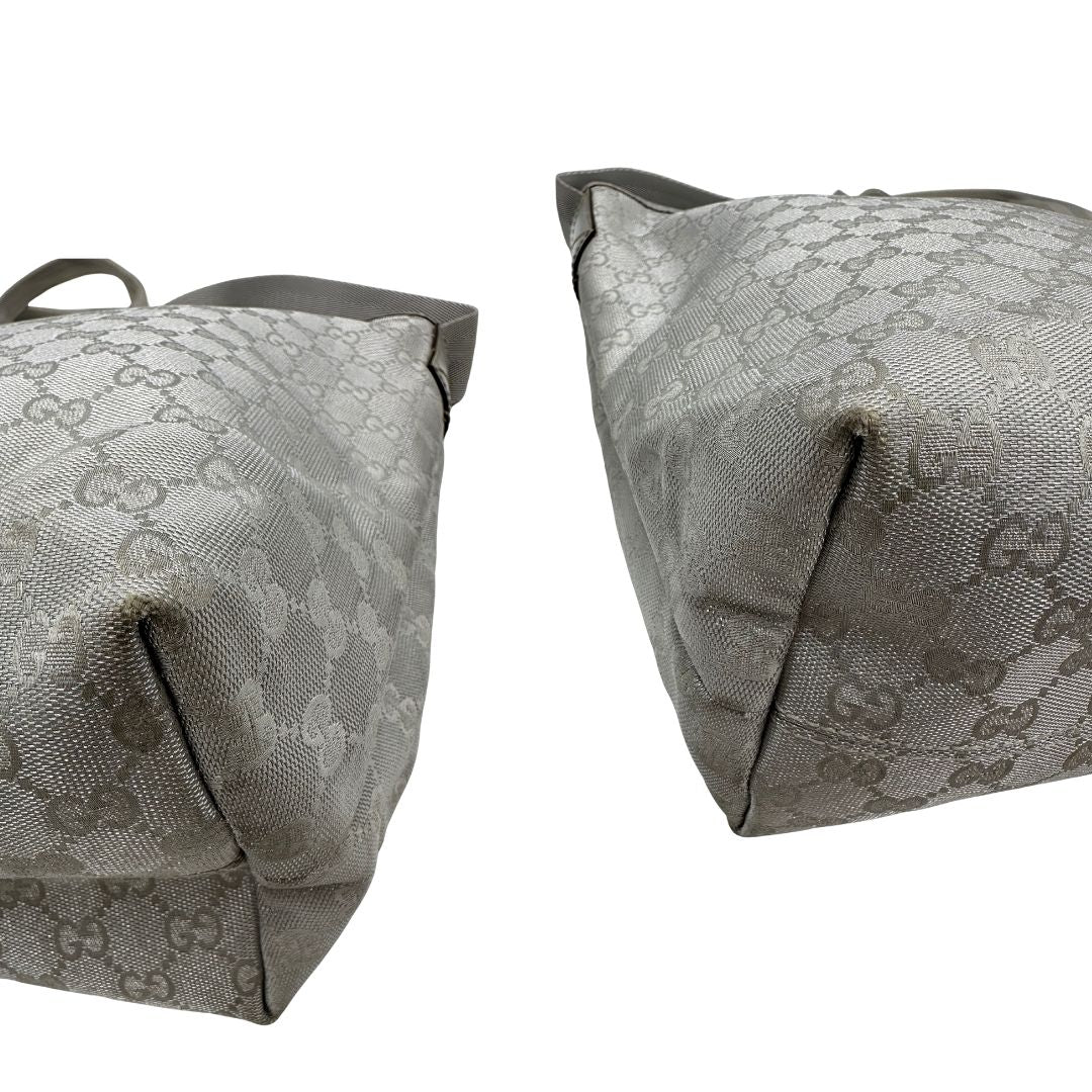 Angoli Borsa Gucci in canvas grigio laminato GG con finiture in pelle Tono su tono e parti metalliche argentate. Dotata di Doppi manici e tracolla in tessuto regolabile.