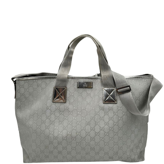Front Borsa Gucci in canvas grigio laminato GG con finiture in pelle Tono su tono e parti metalliche argentate. Dotata di Doppi manici e tracolla in tessuto regolabile.