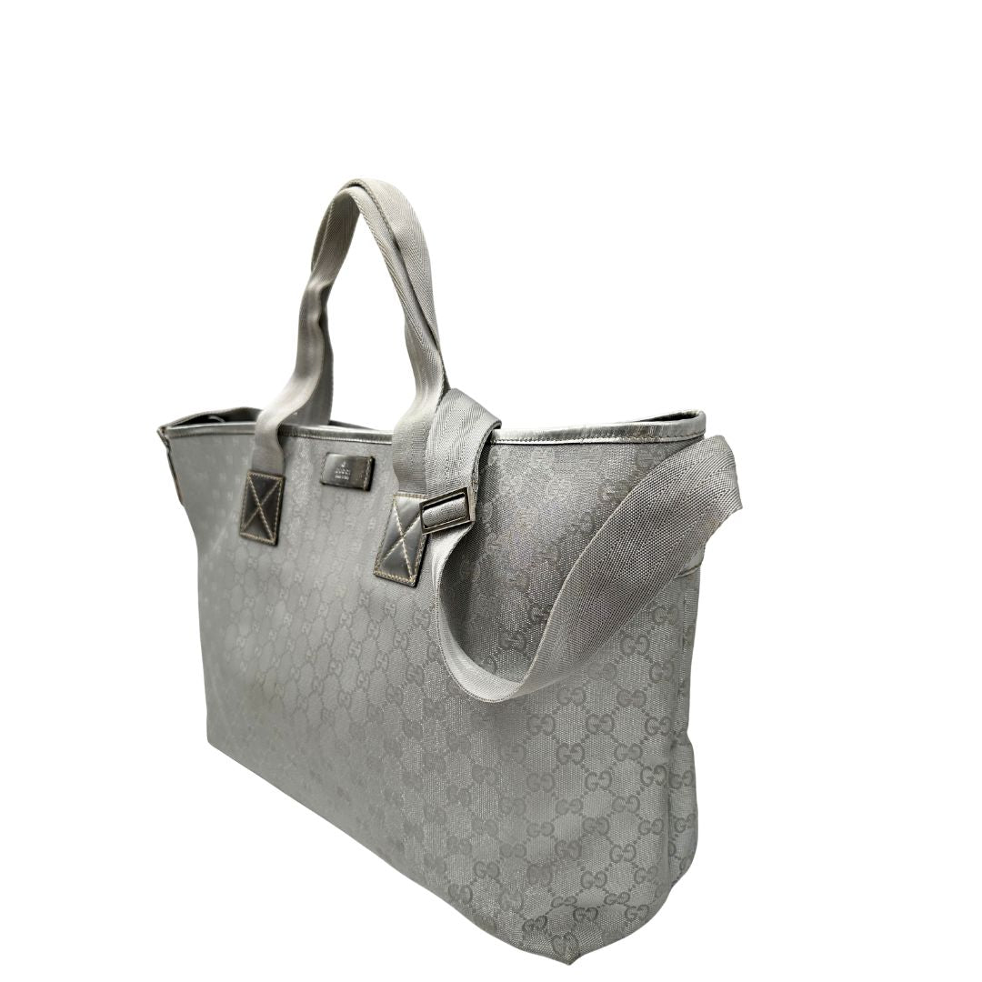 Laterali Borsa Gucci in canvas grigio laminato GG con finiture in pelle Tono su tono e parti metalliche argentate. Dotata di Doppi manici e tracolla in tessuto regolabile.