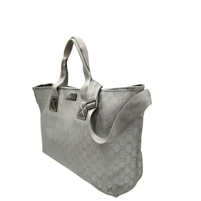 Laterali Borsa Gucci in canvas grigio laminato GG con finiture in pelle Tono su tono e parti metalliche argentate. Dotata di Doppi manici e tracolla in tessuto regolabile.
