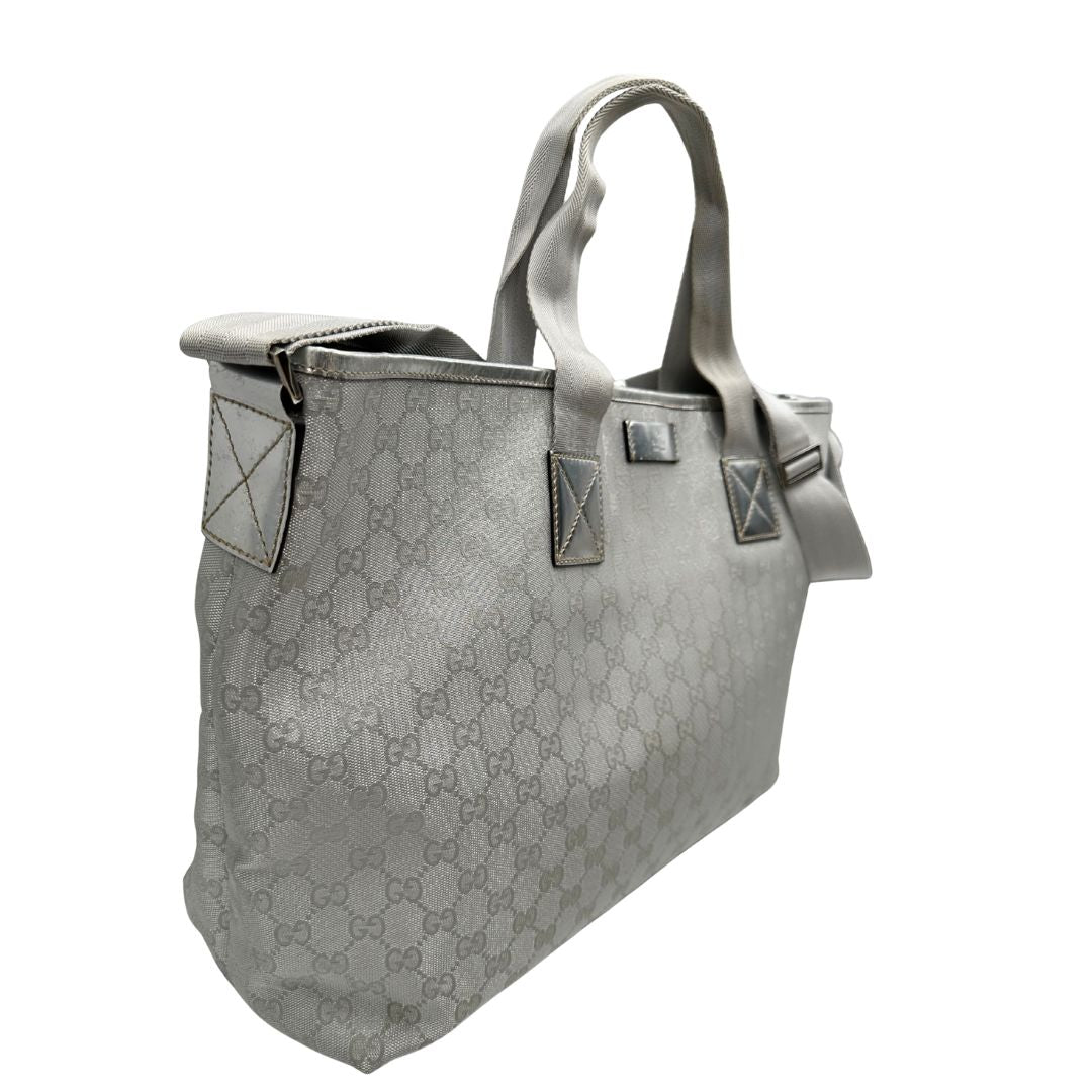 Laterali Borsa Gucci in canvas grigio laminato GG con finiture in pelle Tono su tono e parti metalliche argentate. Dotata di Doppi manici e tracolla in tessuto regolabile.