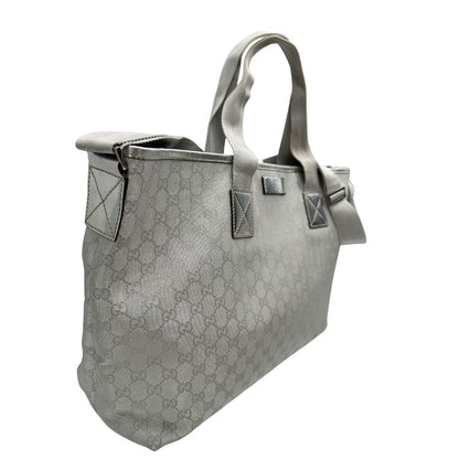 Laterali Borsa Gucci in canvas grigio laminato GG con finiture in pelle Tono su tono e parti metalliche argentate. Dotata di Doppi manici e tracolla in tessuto regolabile.