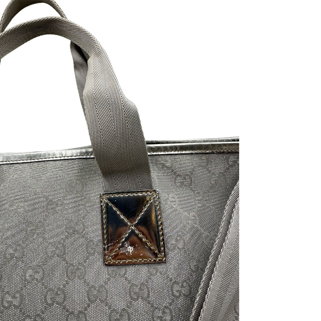 Borsa Gucci in canvas grigio laminato GG con finiture in pelle Tono su tono e parti metalliche argentate. Dotata di Doppi manici e tracolla in tessuto regolabile.